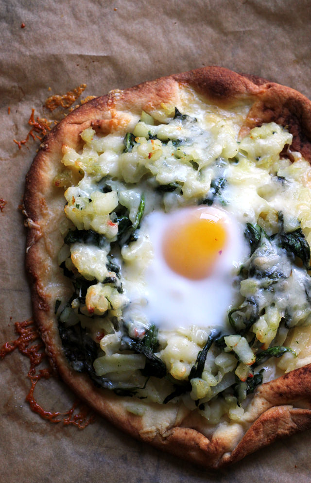 breakfast pizza with hash browns, spinach, and eggs